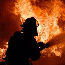 Feuerwehrmann, der gerade dabei ist ein Feuer zu löschen.